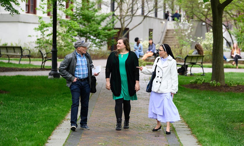 Three students walking across campus