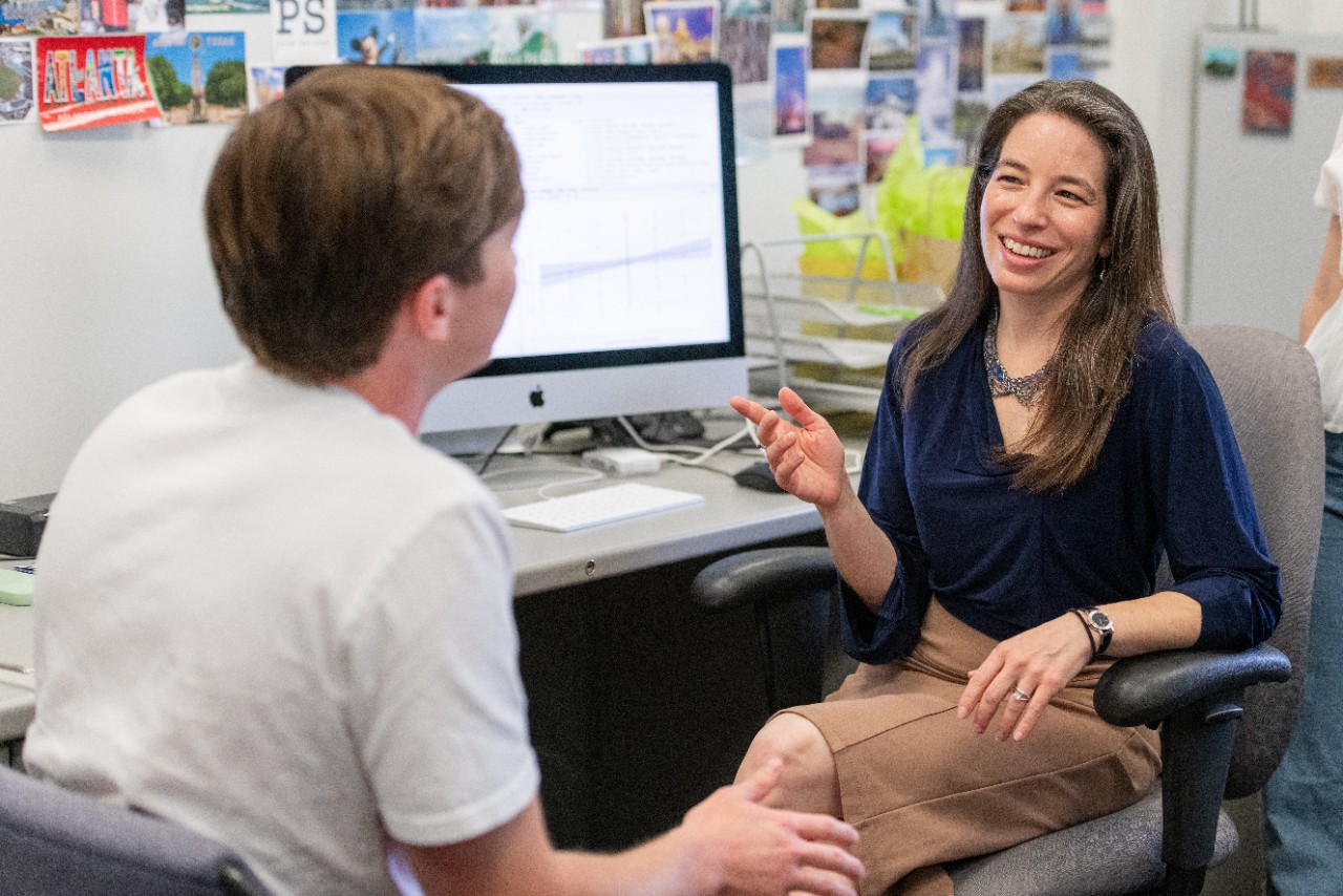 Dr. Weisberg, seated, speaks with a student