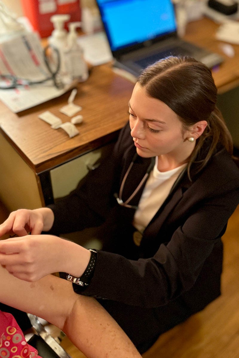 A student volunteer taking vitals