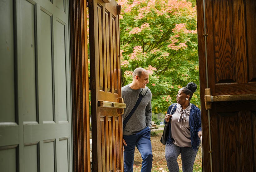 paralegal-students-walking-through-wooden-door-on-campus