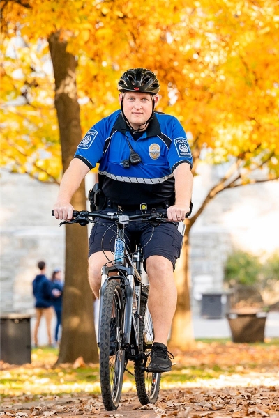 Public safety officer biking through campus
