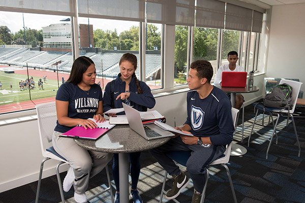 Student athletes work together at a table.