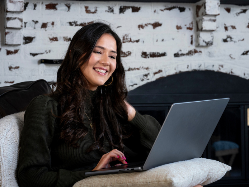 woman sitting on a sofa looking at a laptop