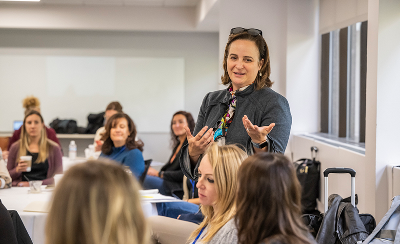 faculty member, Terri Boyer, stands in the middle of a class of professional adult students