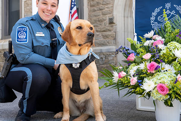 Taffy, a golden retriever, sits with her handler Officer Amy Lenahan.